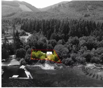 Aerial view of Honeymoon Bay showing a property highlighted with a red border against a predominantly grayscale backdrop, indicating a significant property value adjustment amidst lush forest scenery.